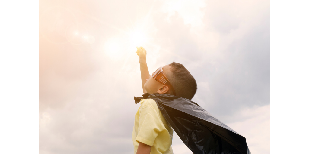 happy child wearing a hero cape 